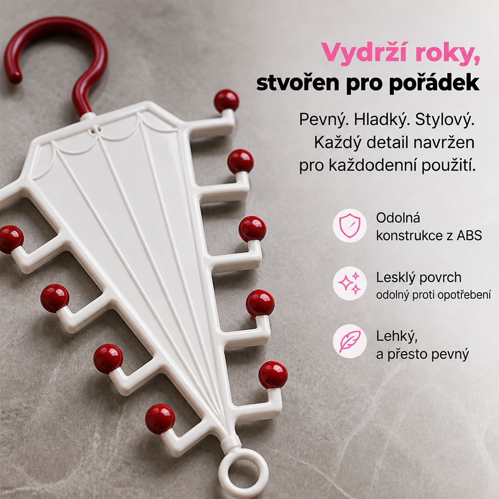 Detail bílého věšáku s tmavě červenými kuličkami a háčkem na šedém kamenném podkladu 3