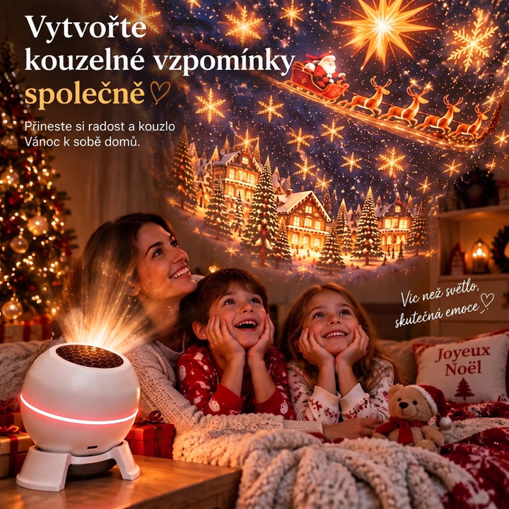 Usměvavá maminka s dvěma dětmi v pyžamu leží pod dekou a obdivují vánoční projekci Santy, sobů a zasněžených domků. 4
