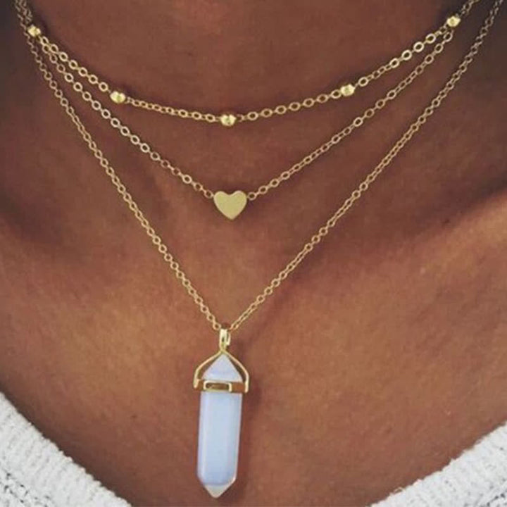 Dreifache goldene Halskette mit Herzanhänger und blauem Kristall, modischer Schmuck.