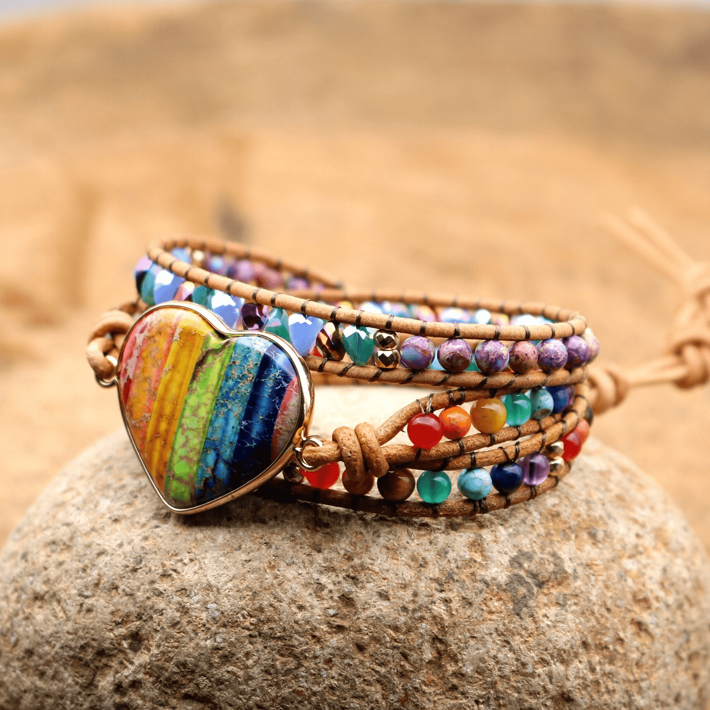 Buntes Chakra-Wickelarmband mit Herzanhänger, handgefertigt, Boho-Stil, auf Stein.