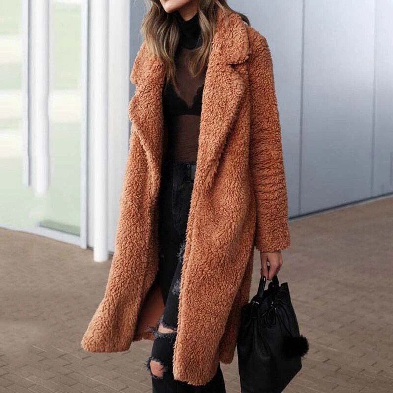 Frau in braunem Teddy-Mantel, schwarze Jeans, schwarze Tasche, Wintermode, stilvoll.