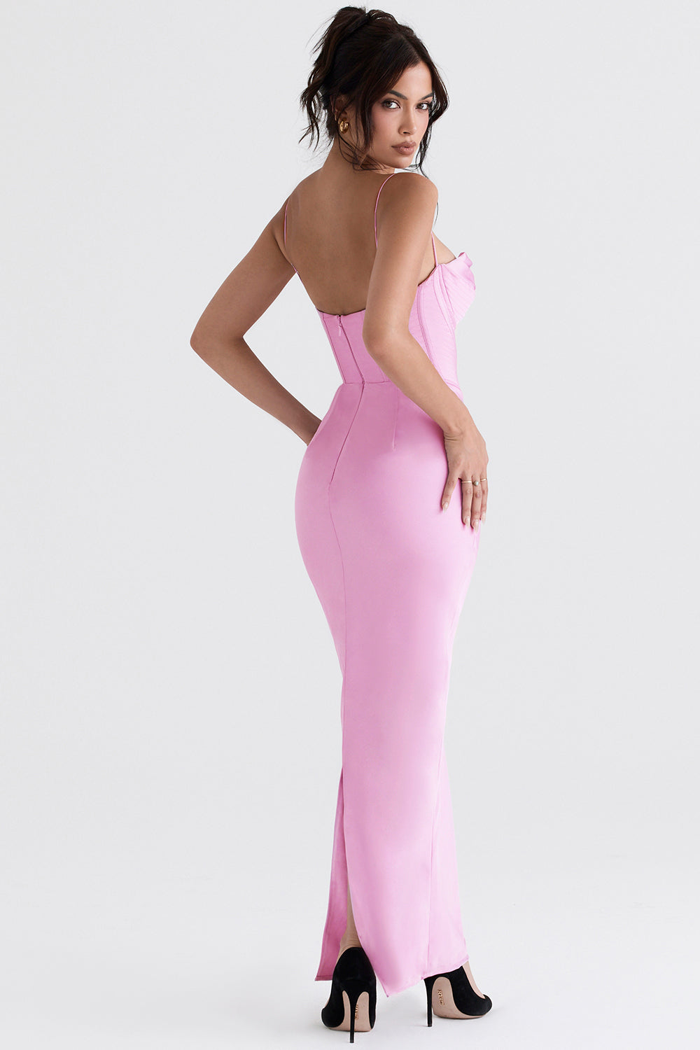 Frau in rosa Abendkleid, schulterfrei, figurbetont, elegantes Design, schwarze High Heels.