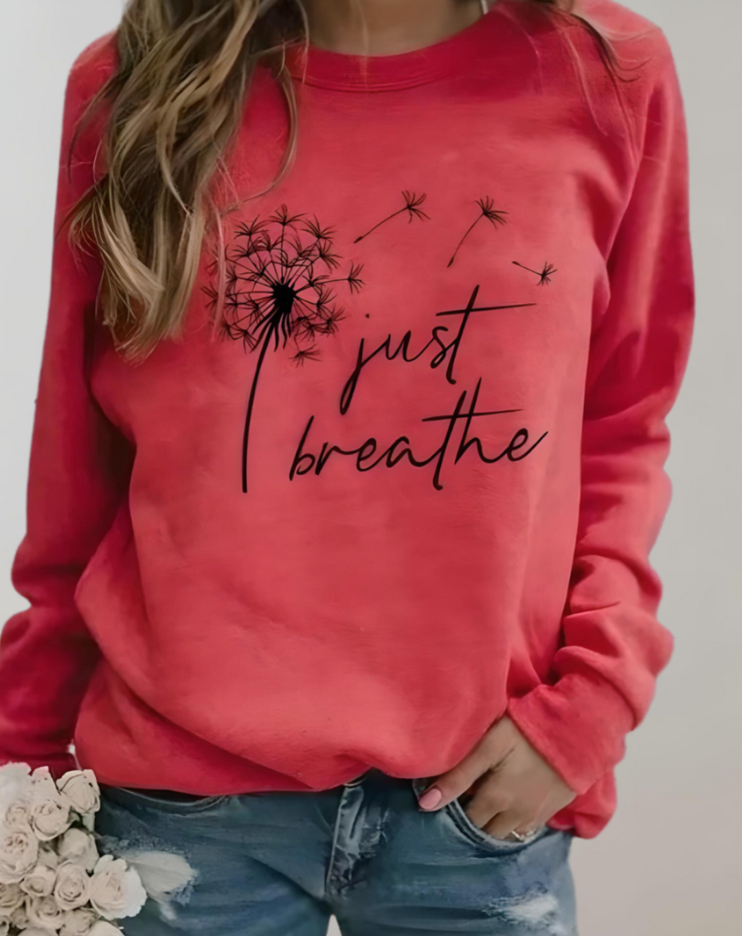 Frau in rotem "Just Breathe" Pullover, Löwenzahn-Motiv, lässige Mode, Damenbekleidung.