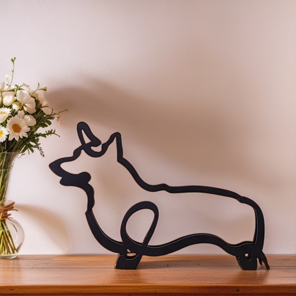 Schwarze Corgi-Skulptur aus Metall auf Holzregal neben Blumenstrauß in Vase.