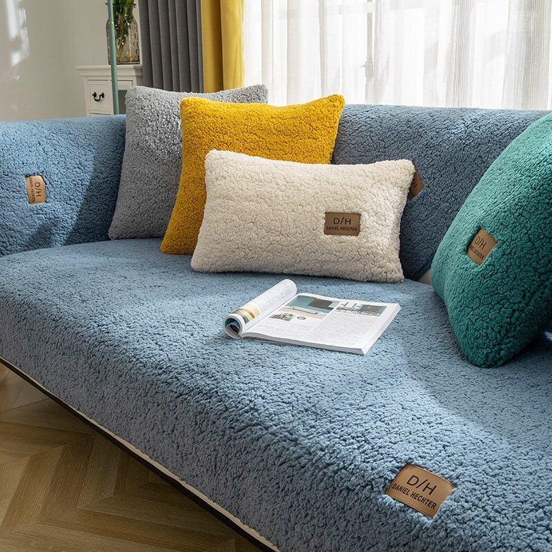Graue Couch mit weichem, flauschigem Überzug, bunte Kissen, modernes Wohnzimmer, gemütlich.