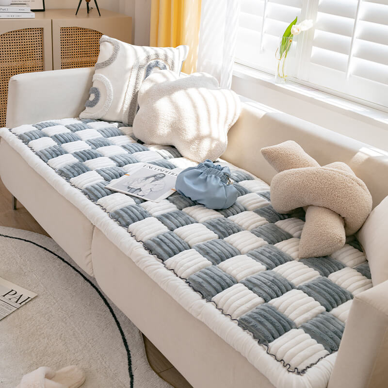 Cremefarbene karierte Haustiermatte auf Sofa, weiches Material, modernes Design, Wohnzimmer.