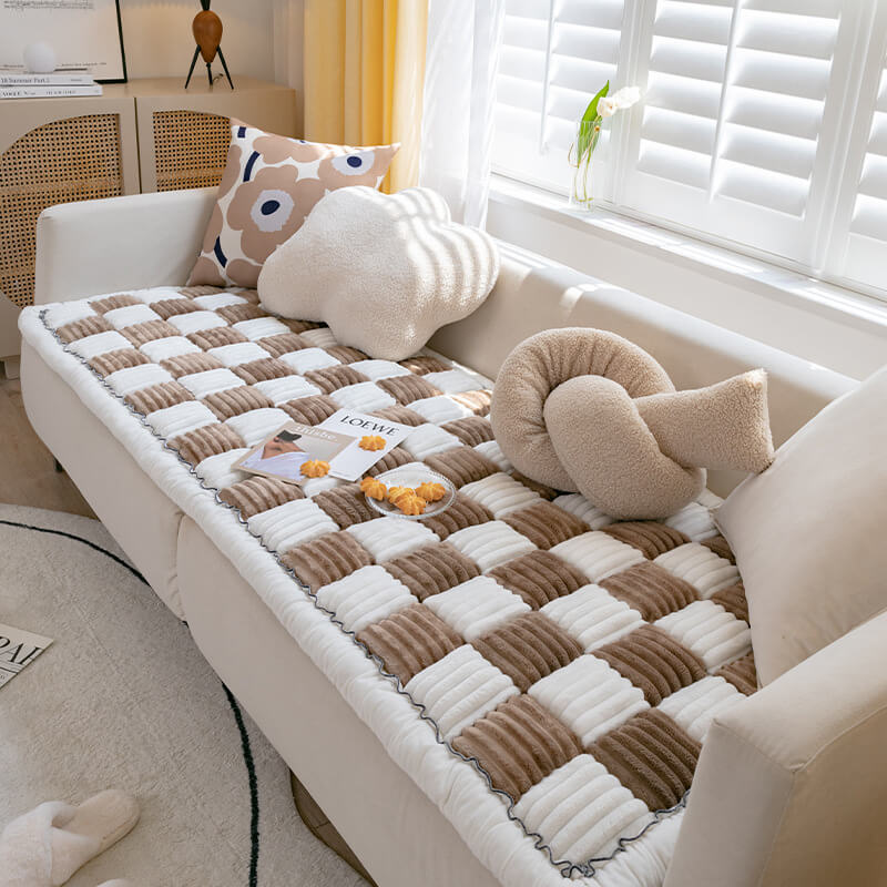 Cremefarbene karierte Haustiermatte auf Sofa, weiches Material, modernes Design, Wohnzimmer.