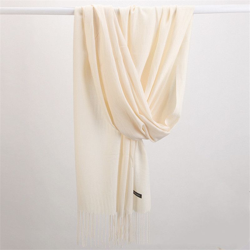 Beiger Kaschmirschal mit Fransen, luxuriöses Accessoire, weiches Material, elegantes Design.