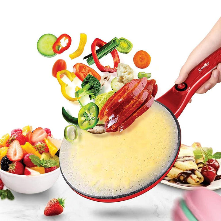 Rote elektrische Pfannkuchenpfanne mit Gemüse und Obst, Antihaftbeschichtung, Küchenzubehör.