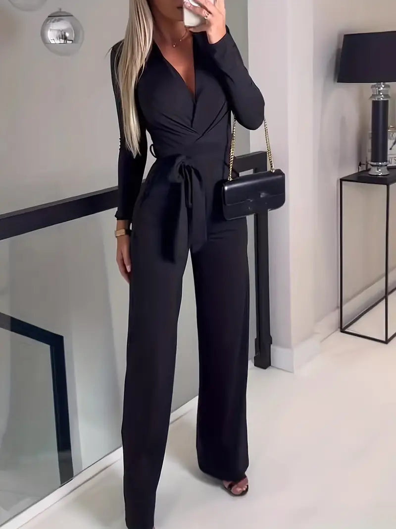 Frau in schwarzem Jumpsuit mit Gürtel, schwarze Handtasche, elegantes Outfit, moderne Mode.