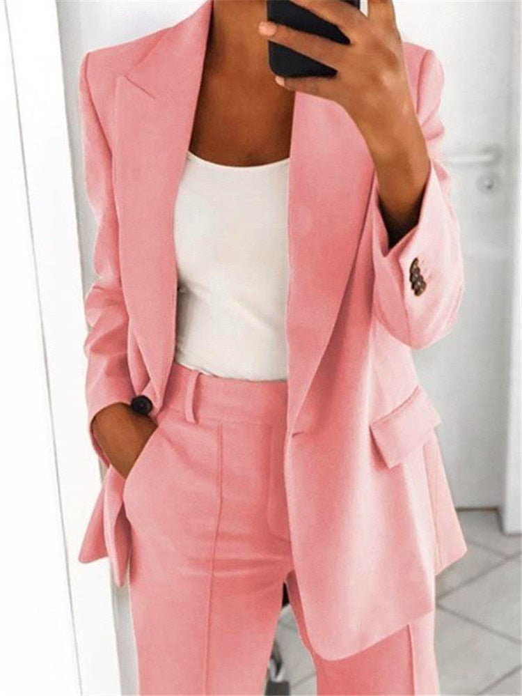 Frau im rosa Anzug mit weißem Top, Businessmode, eleganter Damenanzug, Bürooutfit.