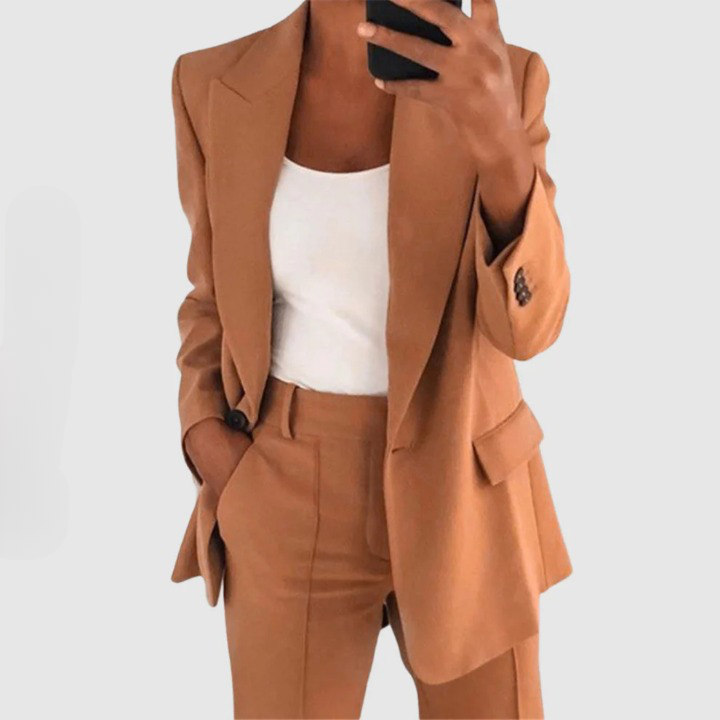 Frau in braunem Anzug und weißem Top, Businessmode, eleganter Stil, Smartphone in der Hand.