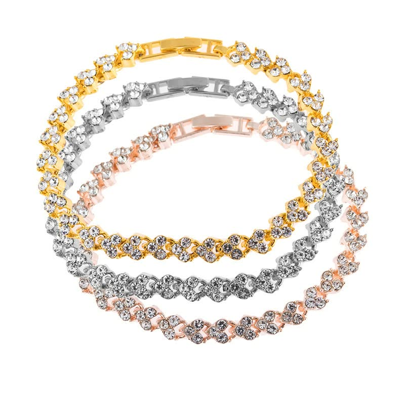 Drei funkelnde Tennisarmbänder in Gold, Silber und Roségold mit Zirkonia-Steinen.