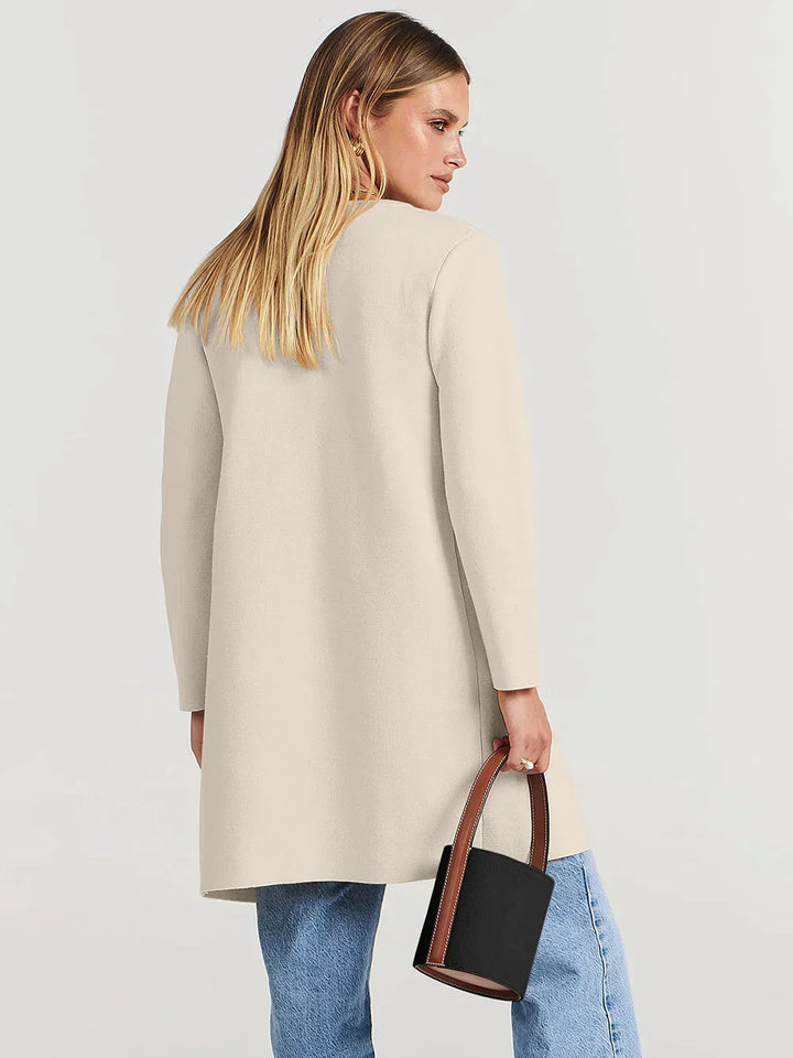 Frau in cremefarbenem Mantel, blaue Jeans, schwarze Handtasche, Mode, Damenbekleidung.
