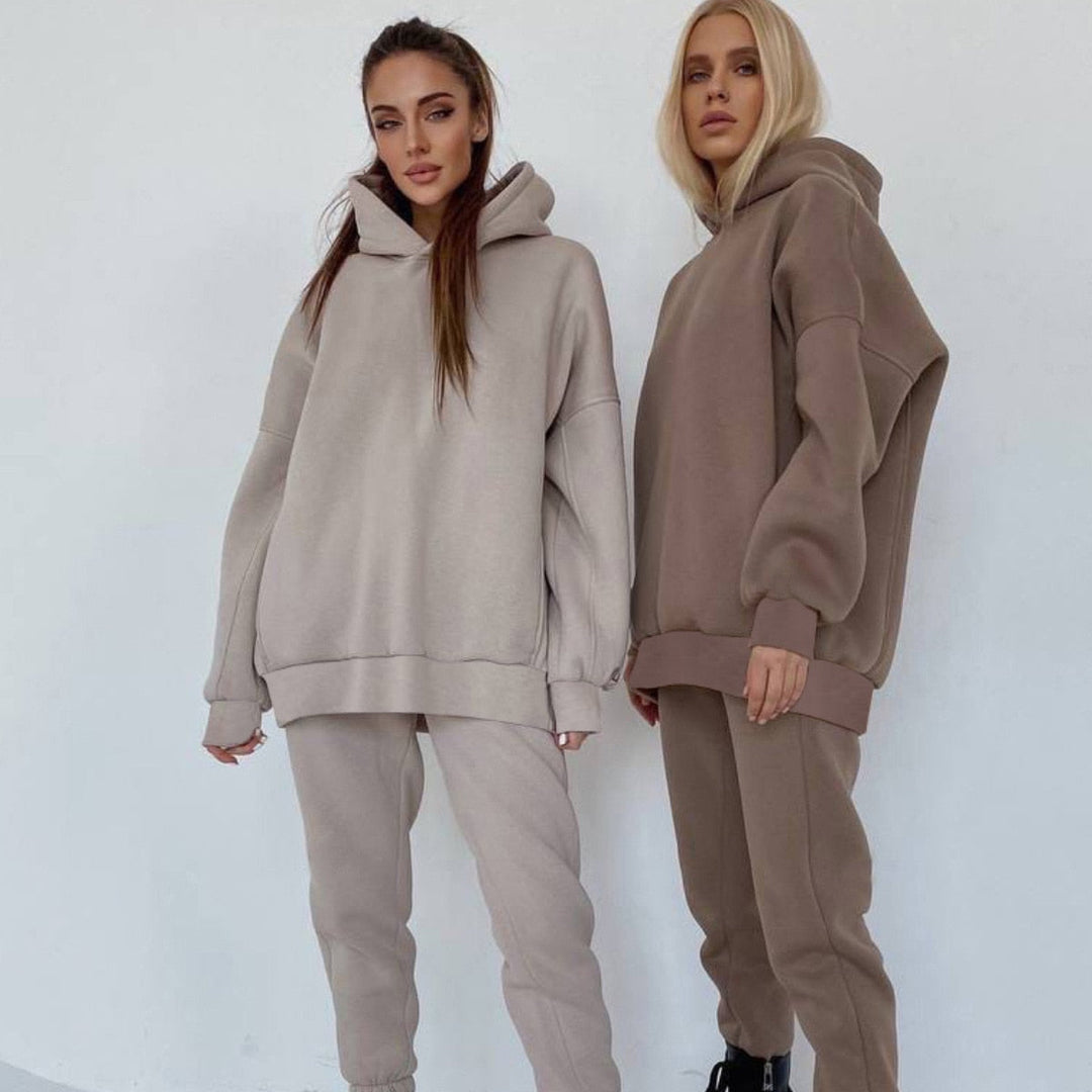 Zwei Frauen in beigen und braunen Oversize-Hoodies und Jogginghosen aus Baumwolle.