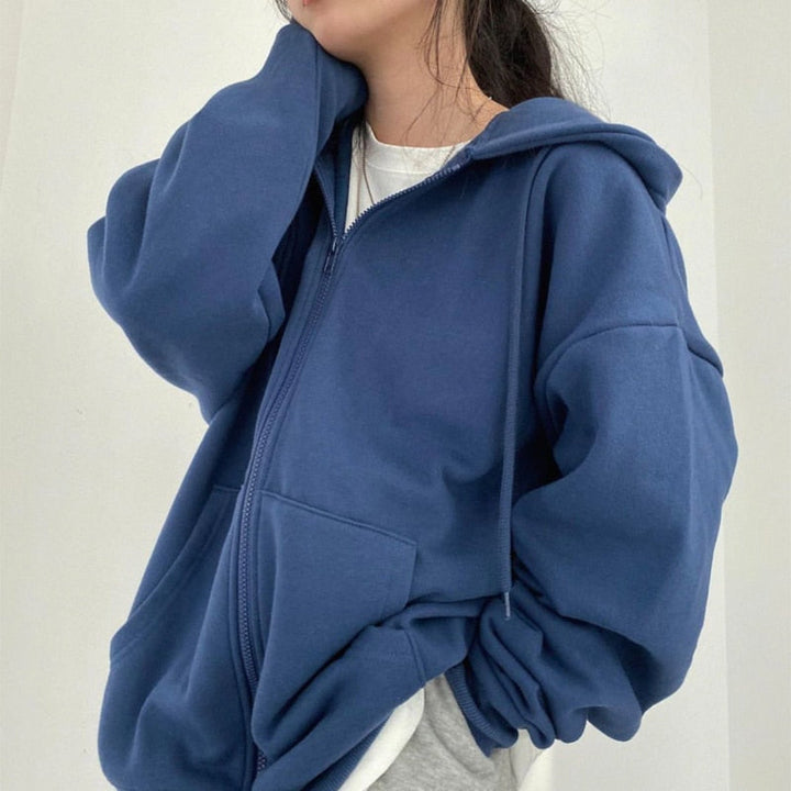 Frau in blauer Kapuzenjacke, lässiger Stil, Baumwolle, Reißverschluss, modisch, bequem.