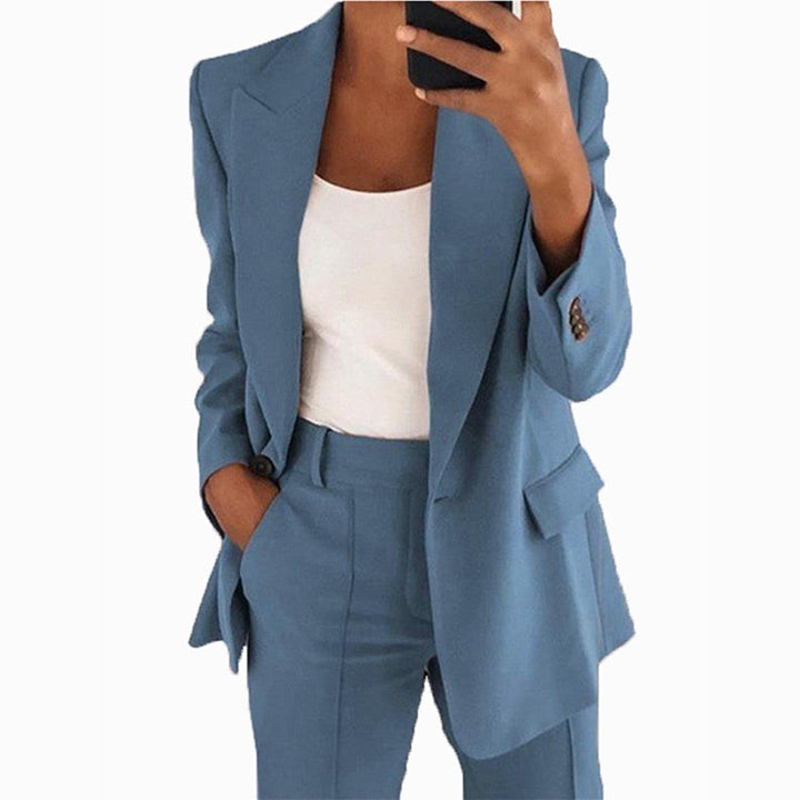 Frau in blauem Anzug mit weißem Top, Businessmode, eleganter Damenanzug, Bürooutfit.