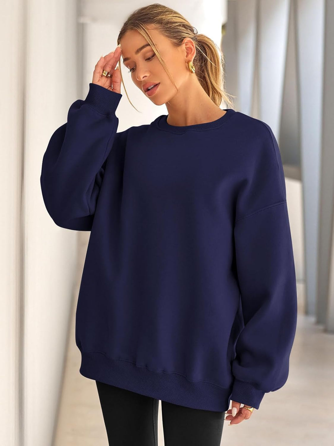 Frau in dunkelblauem Oversize-Pullover, lässiger Stil, modische Damenbekleidung.