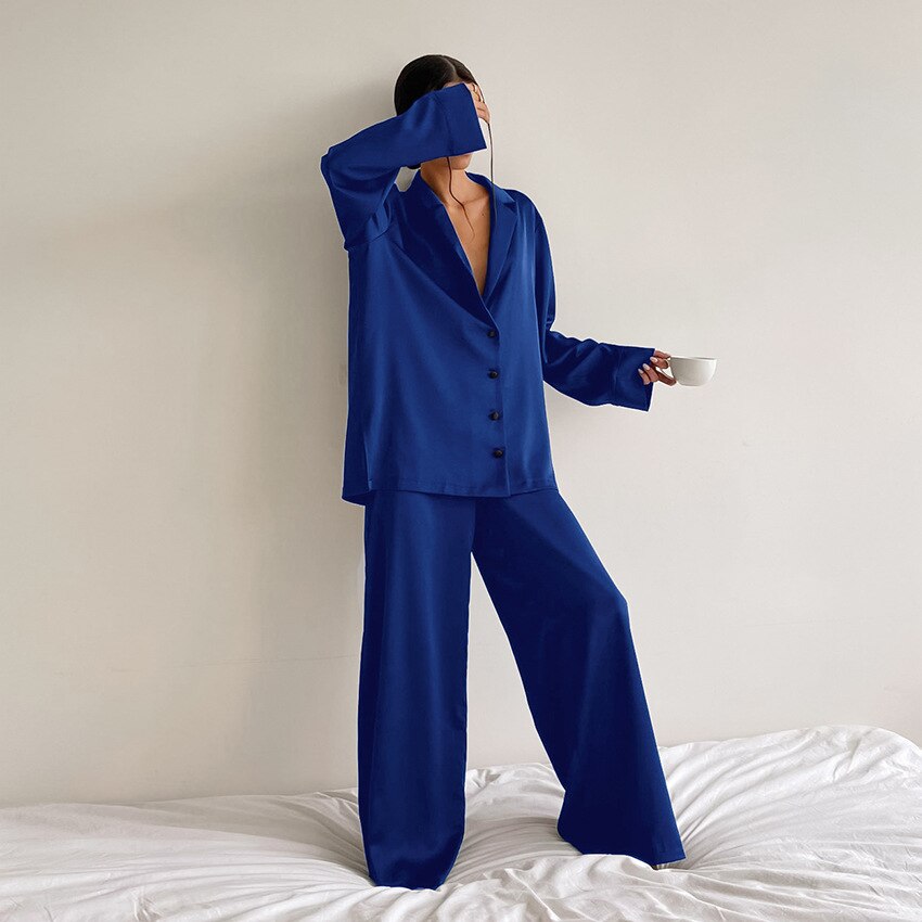Frau in blauem Satin-Pyjama mit Tasse, moderne Nachtwäsche, elegantes Design.