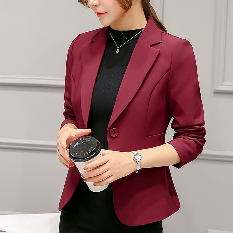 Frau in bordeauxrotem Blazer mit Kaffeebecher, elegantes Business-Outfit, Büro-Mode.