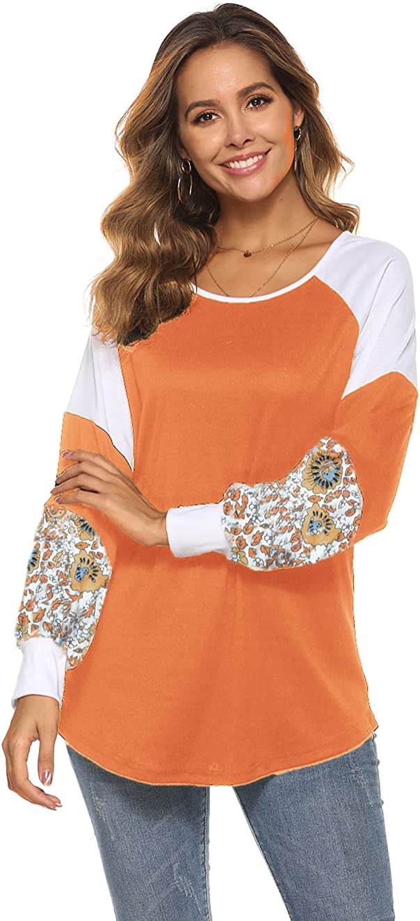 Frau in orange-weißem Langarmshirt mit Blumenmuster, lächelnd, Freizeitmode.