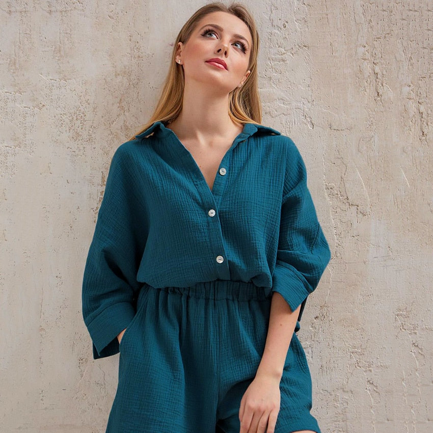 Frau in blauem Leinen-Overall vor beiger Wand, modische Damenbekleidung, Freizeitlook.