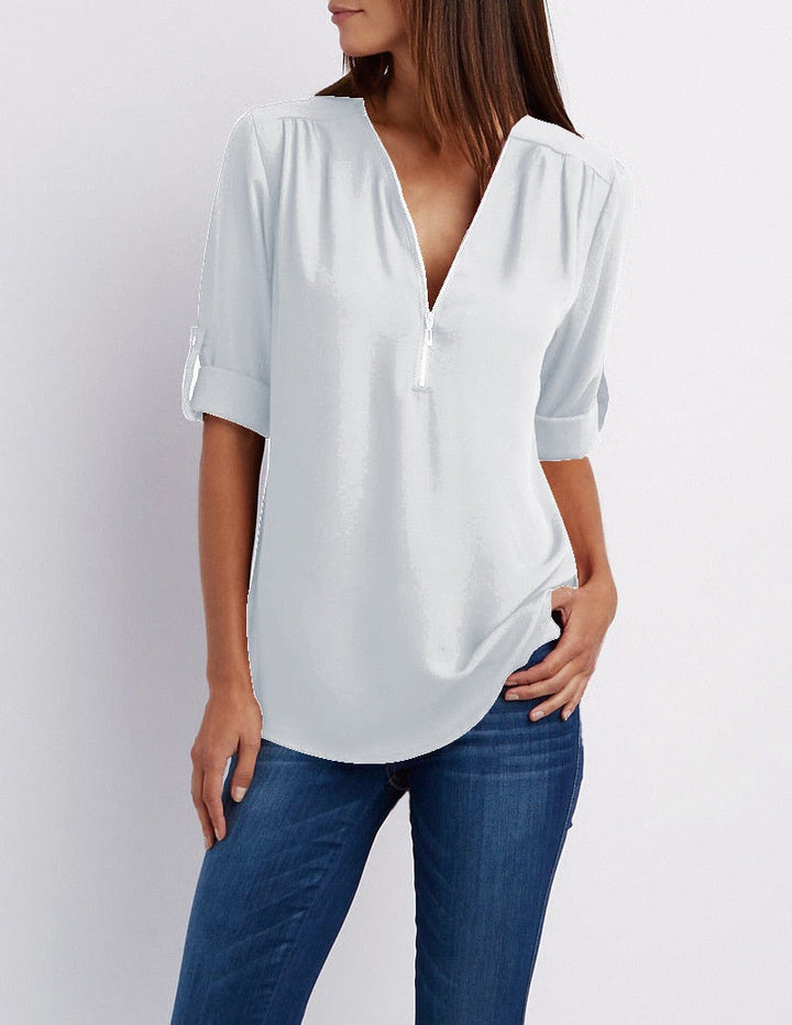 Frau in weißer Bluse mit V-Ausschnitt und blauen Jeans, lässige Damenmode.