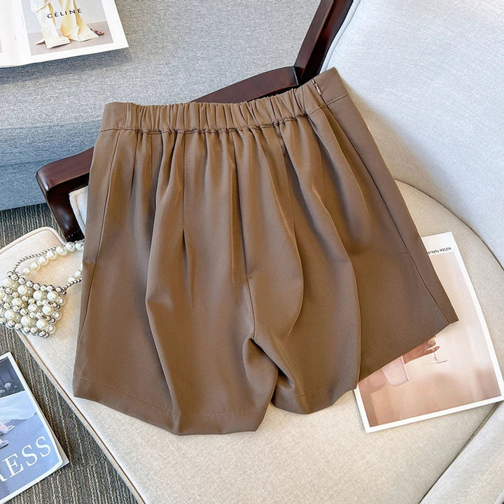 Braune Damen-Shorts aus Baumwolle auf einem Sessel, modisch und bequem für den Sommer.
