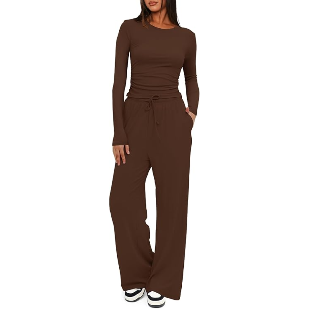 Frau in braunem Langarm-Jumpsuit, lässig, bequem, modisch, mit weißen Sneakers.