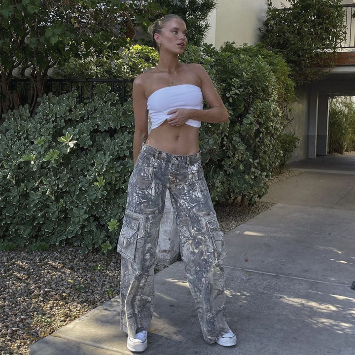 Frau in weißem Bandeau-Top und grauer Cargohose, lässiger Sommerlook, draußen.