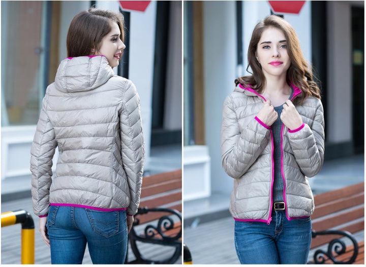 Frau in grauer Daunenjacke mit pinkem Reißverschluss, modisch, outdoor, Herbstmode.