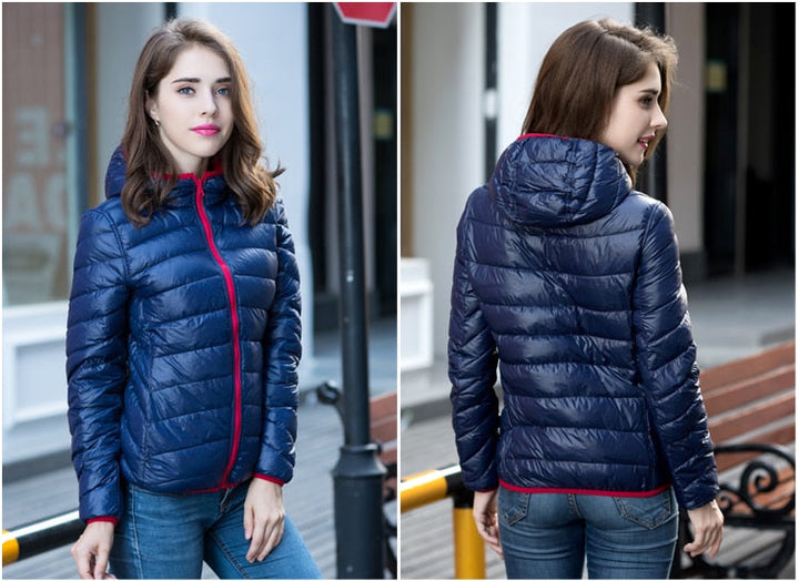 Frau in blauer Daunenjacke mit Kapuze, rotem Reißverschluss, modisch, outdoor, Herbstmode.