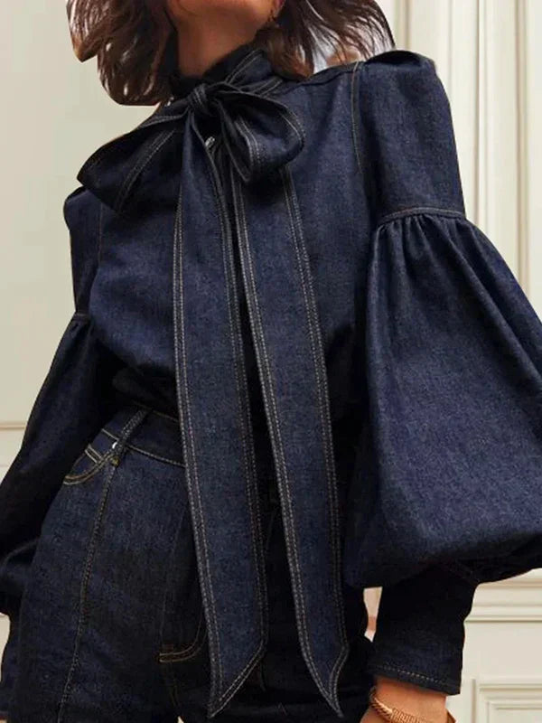 Frau in dunkelblauer Jeansbluse mit Puffärmeln und Schleife, modisch, elegant, Damenmode.