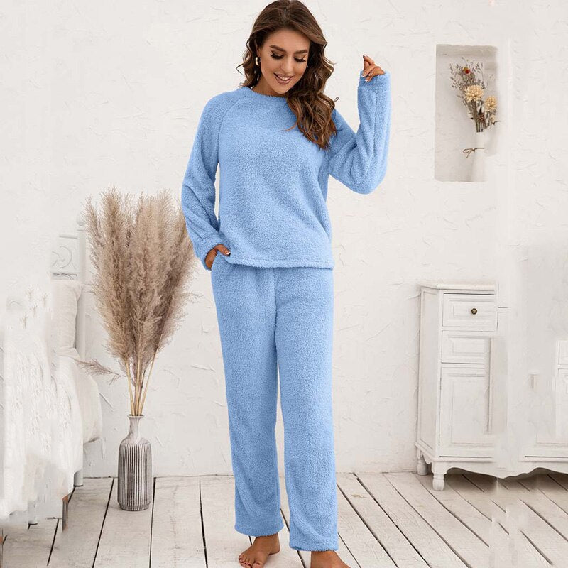 Frau in hellblauem Fleece-Pyjama-Set, gemütlich, langärmelig, für Damen, Schlafzimmer.