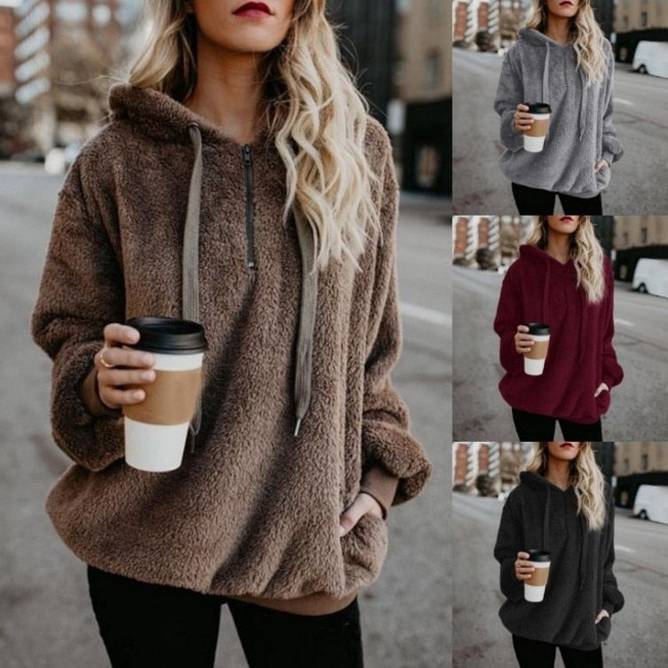 Frau in braunem Fleece-Hoodie mit Kaffeebecher, Herbstmode, gemütlicher Kapuzenpullover.