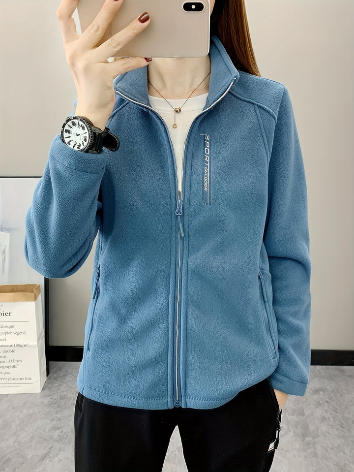 Frau in blauer Fleecejacke mit Reißverschluss, Sportuhr, lässiger Stil, Innenaufnahme.