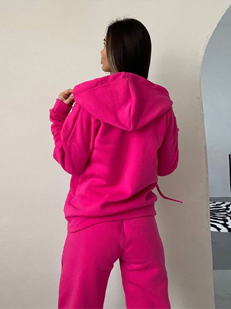 Frau in pinkem Kapuzenpullover und Jogginghose, Freizeitmode, gemütlicher Stil.