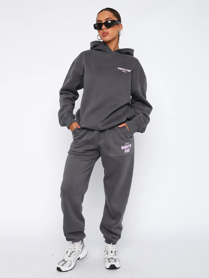 Frau in grauem Hoodie und Jogginghose, Sonnenbrille, sportlich, lässige Mode, Streetwear.