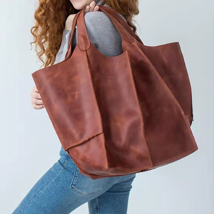 Frau mit großer brauner Ledertasche, modisch, robust, ideal für Alltag und Shopping.
