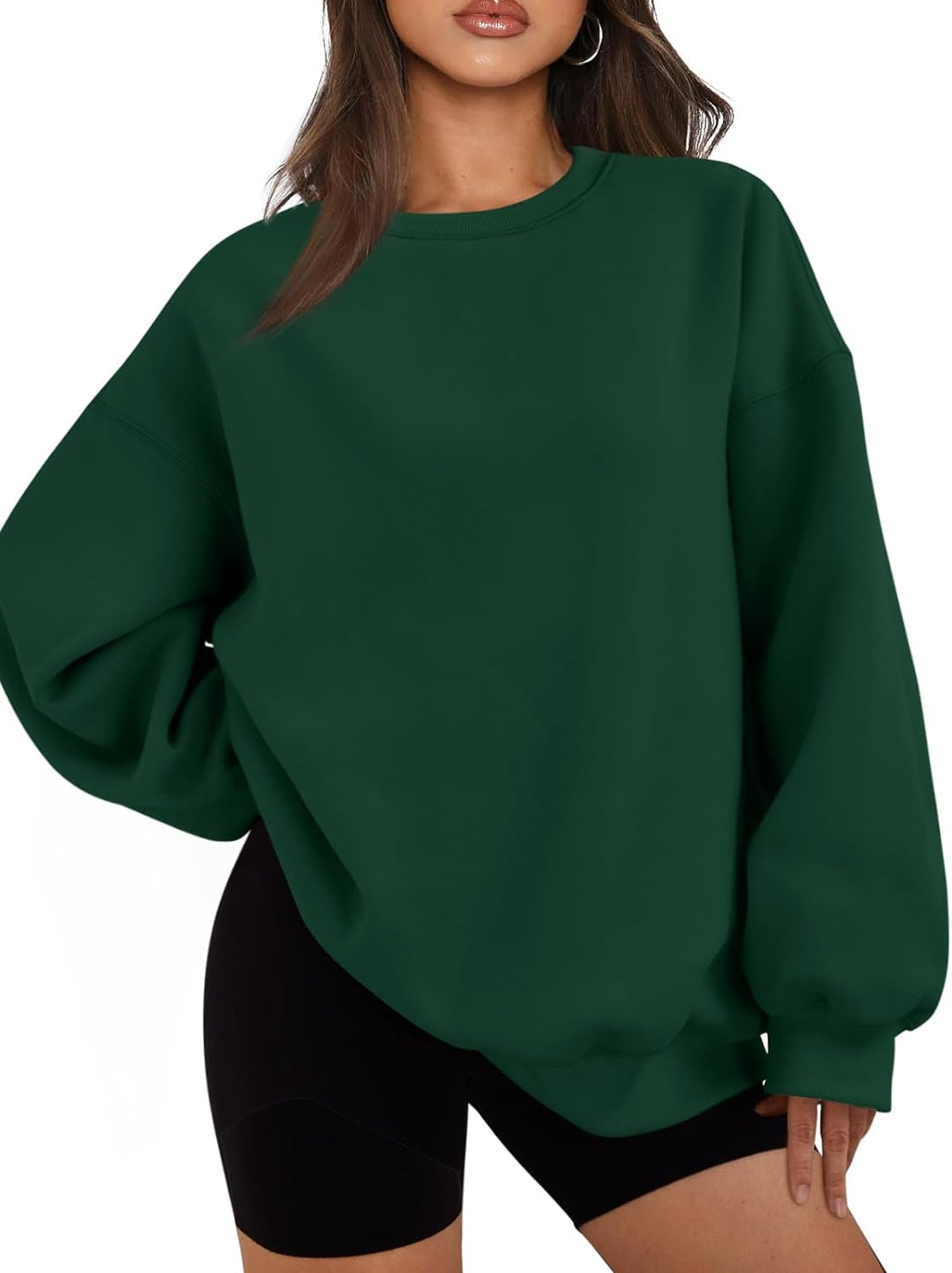 Frau trägt grünes Oversize-Sweatshirt, lässig, modisch, ideal für Herbstmode, Damenbekleidung.