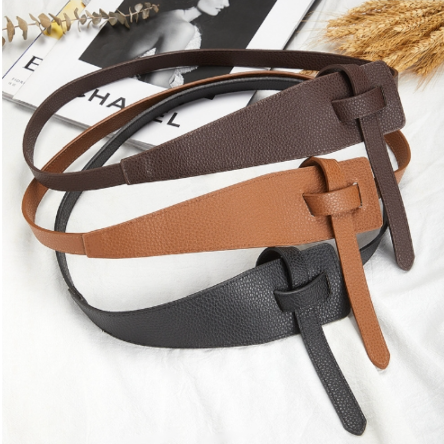 Drei Ledergürtel in Schwarz, Braun und Beige auf einem Tisch, modisches Accessoire für Damen.