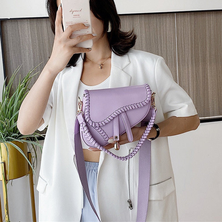 Frau mit lila Umhängetasche aus Leder, modisches Accessoire, elegantes Design.
