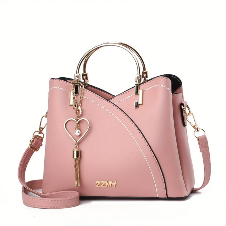 Rosa Damenhandtasche aus Leder mit Herzanhänger, goldene Details, modisch, elegant.