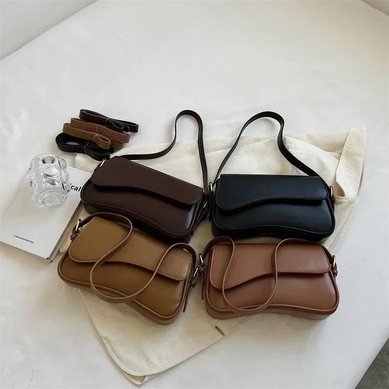 Vier Umhängetaschen aus Leder in Schwarz, Braun und Beige auf weißem Hintergrund.