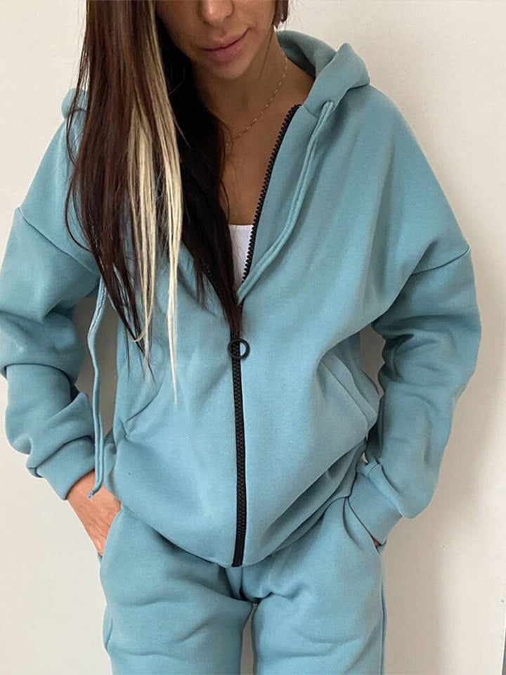 Frau in hellblauem Kapuzenpullover und Jogginghose, Freizeitmode, bequeme Damenbekleidung.