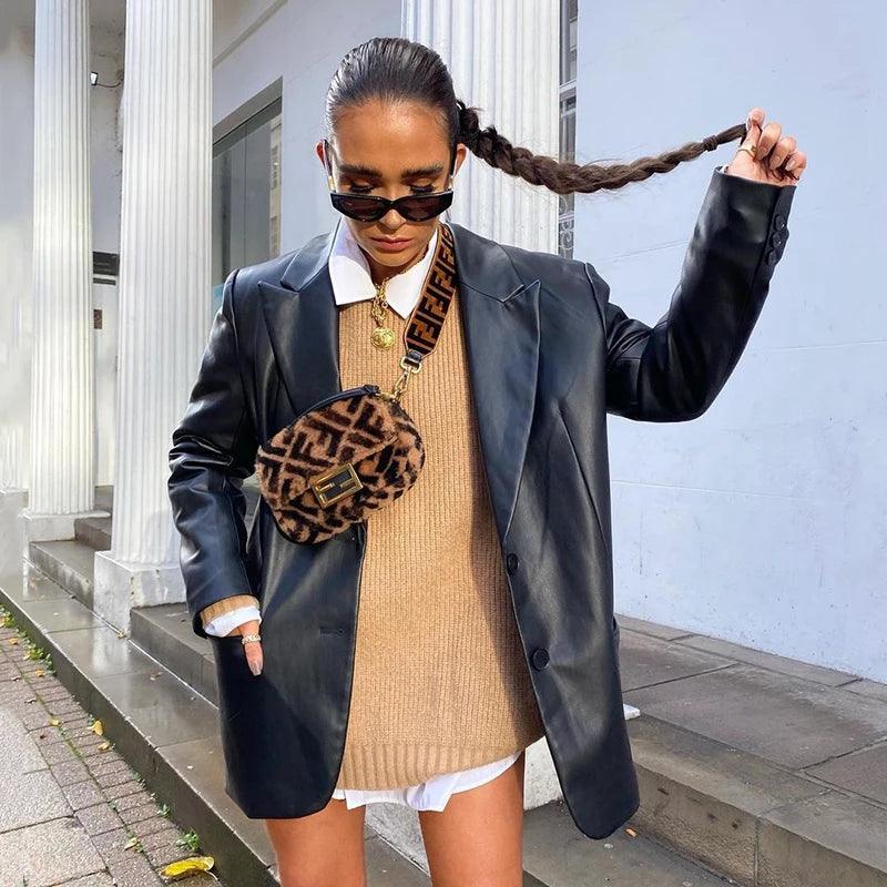 Frau in schwarzer Lederjacke, braunem Pullover, Sonnenbrille, mit Fendi-Tasche, Herbstmode.