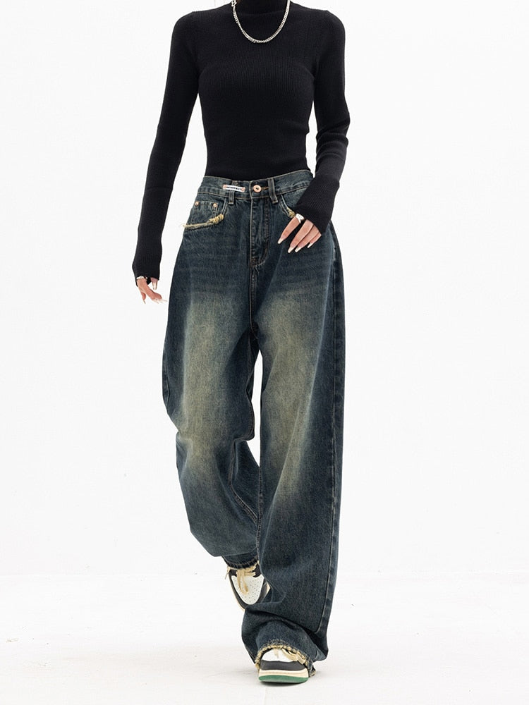 Frau in schwarzem Rollkragenpullover und weiten Jeans, modisch, lässig, urbaner Stil.