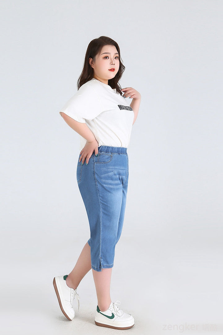 Frau in blauer Jeans-Caprihose und weißem T-Shirt, Plus-Size-Mode, seitliches Profil.