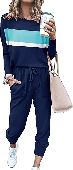 Frau in blauem Jogginganzug mit Streifen, hält Kaffeebecher, beige Tasche, weiße Sneaker.