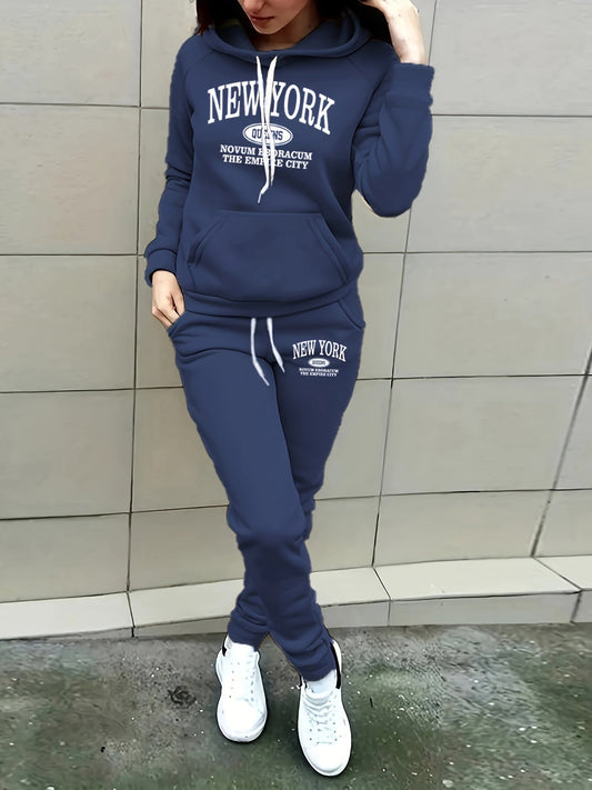 Frau in dunkelblauem New York Hoodie und Jogginghose, weiße Sneakers, lässige Mode.